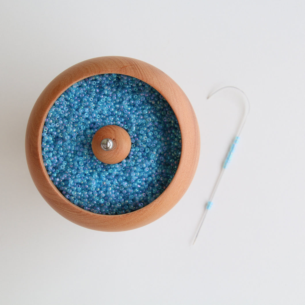 Rotating pot for attaching beads to string